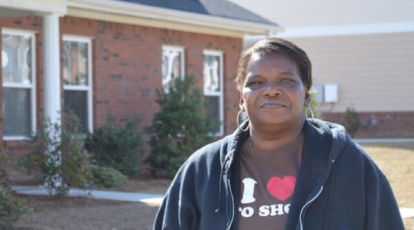 Woman smiling in front of house